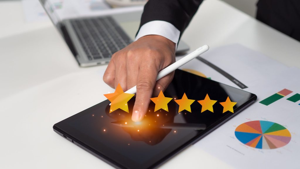 Hand tapping a glowing five-star rating on a tablet screen